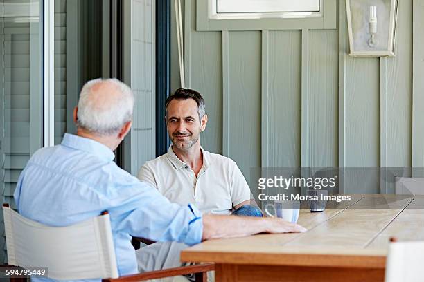 man with father spending leisure time - coffee on patio stock pictures, royalty-free photos & images