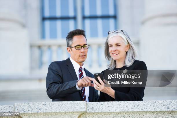 business people using cell phone outside courthouse - people associated with politics & government stock pictures, royalty-free photos & images