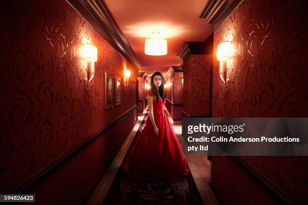 middle eastern woman wearing evening gown in hallway - ballkleider stock-fotos und bilder