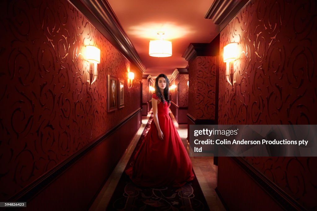 Middle Eastern woman wearing evening gown in hallway