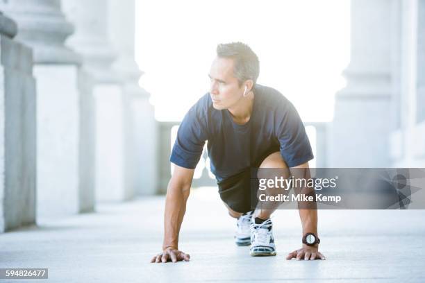 mixed race man stretching outside courthouse - mann 50 style stock-fotos und bilder