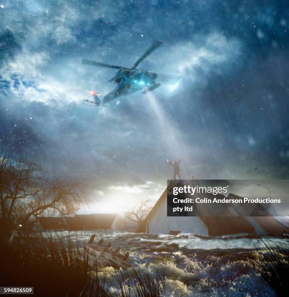 helicopter saving caucasian people from flooded house - red couple stockfoto's en -beelden