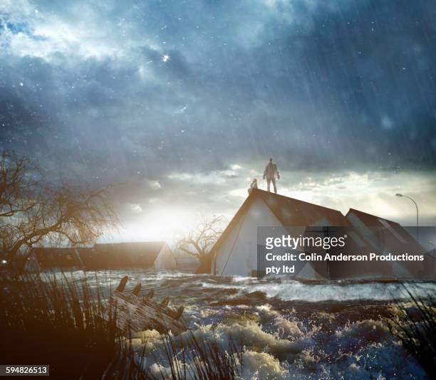 caucasian people standing on roof of flooded house - home disaster fotografías e imágenes de stock