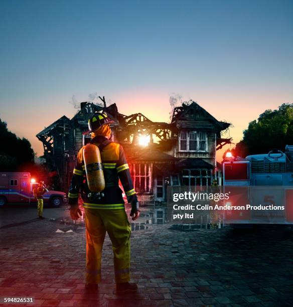 caucasian firefighter at burned house - rescue worker stock pictures, royalty-free photos & images