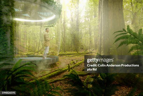 asian man standing on patio in rain forest - origins imagens e fotografias de stock