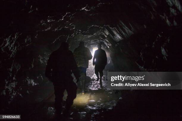 men walking in dark cave - miner stockfoto's en -beelden