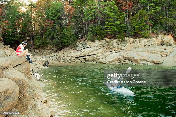 woman watching boyfriend in kayak in lake - canoeing and kayaking stock pictures, royalty-free photos & images