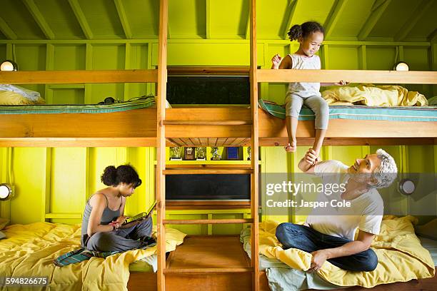 father and daughters relaxing at camp - bunk beds for 3 stock-fotos und bilder