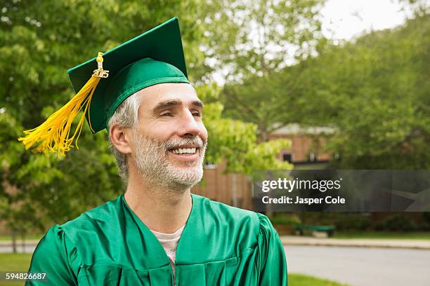 caucasian college graduate wearing cap and gown - 卒業ガウン ストックフォトと画像