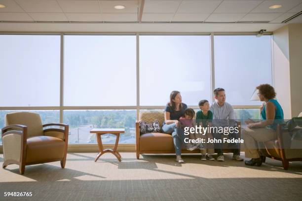 doctor talking to patients in waiting room - families meeting inside stock pictures, royalty-free photos & images