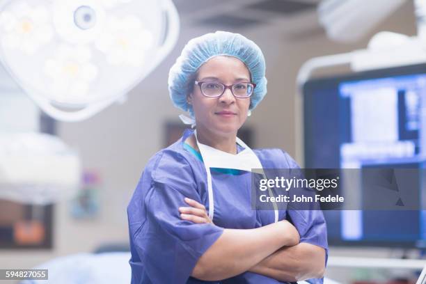 african american surgeon in operating room - chirurgenkappe stock-fotos und bilder