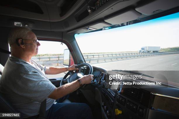 caucasian man driving truck on highway - old truck stock-fotos und bilder