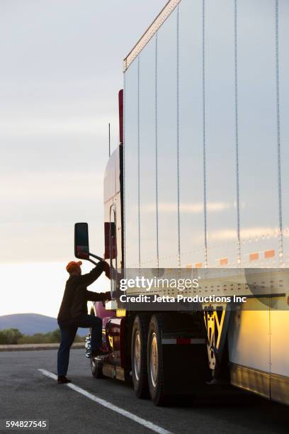 caucasian man climbing into truck - old truck stock-fotos und bilder