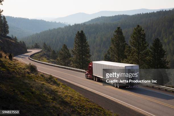 truck driving on remote highway - straßenfracht stock-fotos und bilder