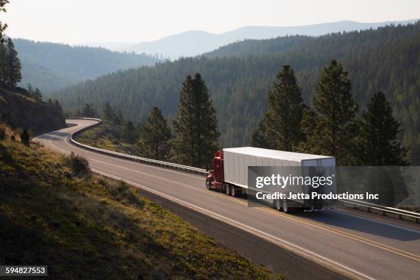 truck driving on remote highway - trucking stock pictures, royalty-free photos & images