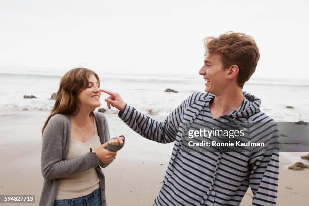 caucasian couple playing on beach - girl hold nose stock pictures, royalty-free photos & images