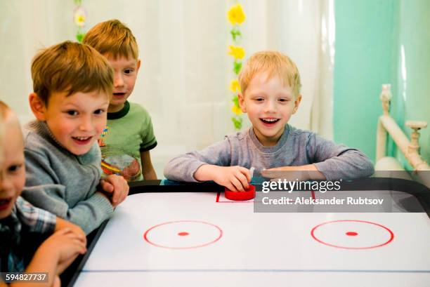 caucasian boys playing air hockey - hockey fans stock pictures, royalty-free photos & images