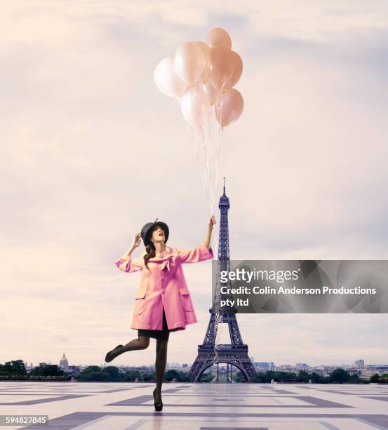 pacific islander woman with balloons near eiffel tower, paris, ile - premium paris stock-fotos und bilder
