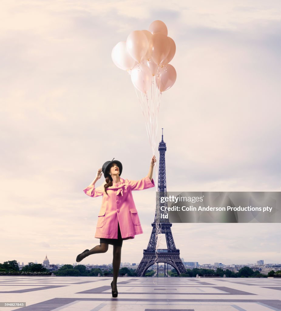 Pacific Islander woman with balloons near Eiffel Tower, Paris, Ile