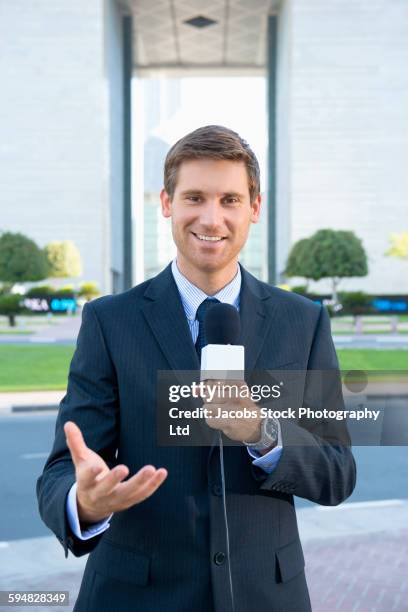 caucasian news anchor talking with microphone - periodista fotografías e imágenes de stock