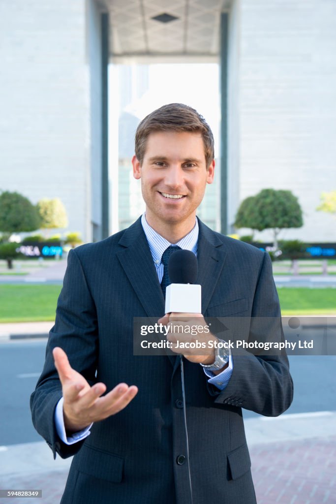 Caucasian news anchor talking with microphone