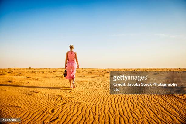 caucasian woman walking barefoot in desert - hot arabian women stock pictures, royalty-free photos & images