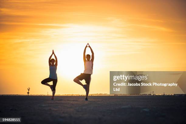 caucasian couple practicing yoga in desert - hot arab women stock pictures, royalty-free photos & images