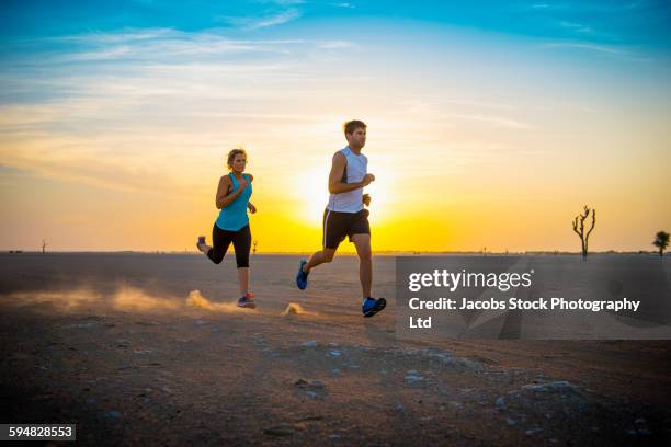 caucasian couple running in desert - hot arabic women fotografías e imágenes de stock