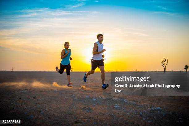 caucasian couple running in desert - hot arabian women stock pictures, royalty-free photos & images