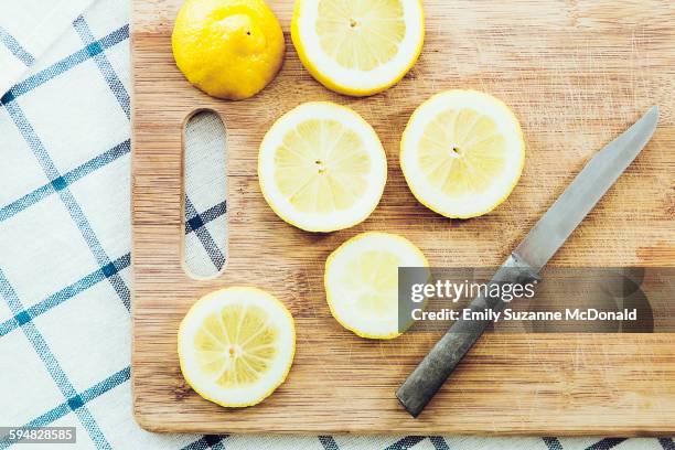 sliced lemon on wooden cutting board - cutting board stock pictures, royalty-free photos & images