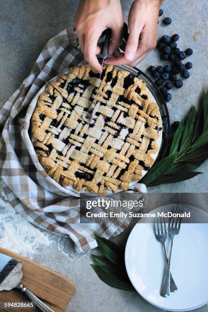 caucasian man slicing blueberry pie - blueberry pie stock pictures, royalty-free photos & images