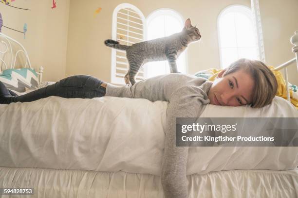 cat climbing on caucasian girl on bed - カリフォルニア州 チノ市 ストックフォトと画像