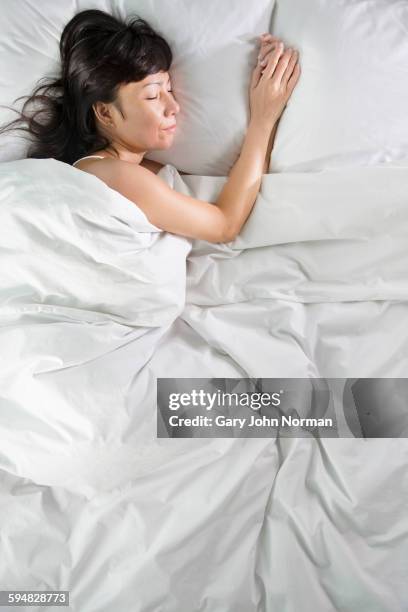 mixed race woman sleeping in bed - woman 45 sleeping stock pictures, royalty-free photos & images