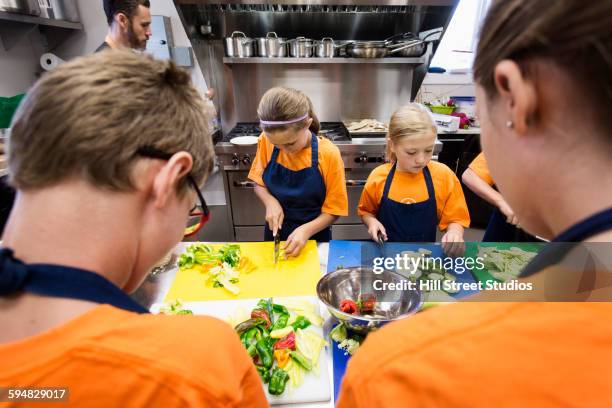 students chopping vegetables in cooking class - home economics class stock pictures, royalty-free photos & images