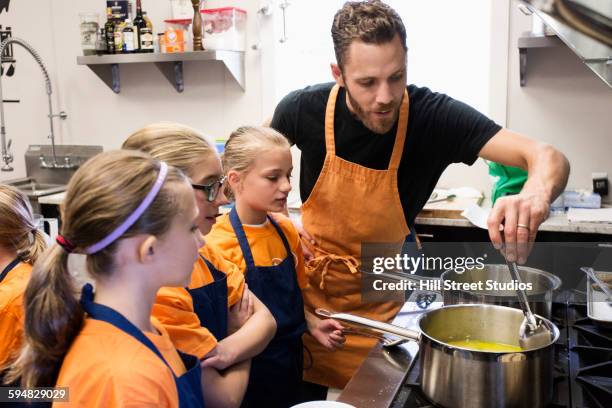 teacher and students cooking in class - children cooking school stock-fotos und bilder