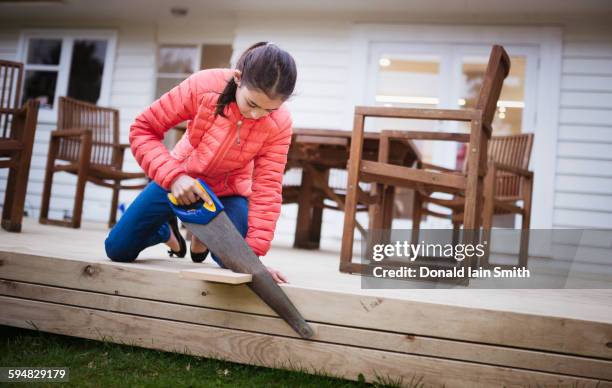 mixed race girl sawing wood in backyard - palmerston north nieuw zeeland stockfoto's en -beelden