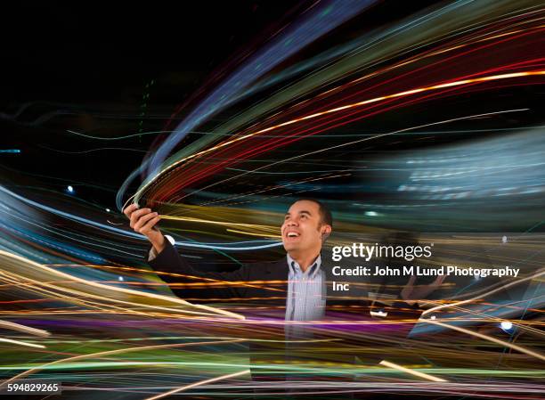 mixed race businessman standing in blurred lights - good technology inc stock pictures, royalty-free photos & images