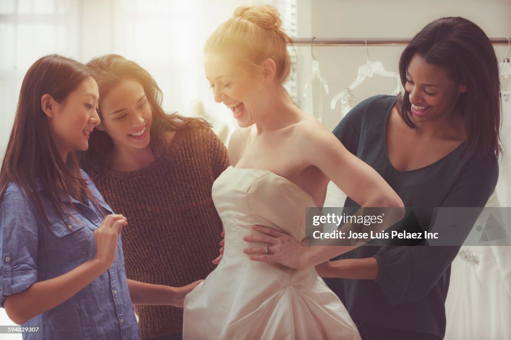 Bride and friends shopping for wedding gown