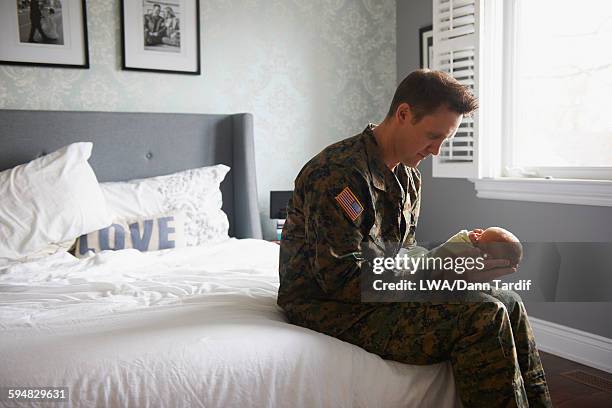 caucasian soldier holding newborn - lwa dann tardif bed stock pictures, royalty-free photos & images