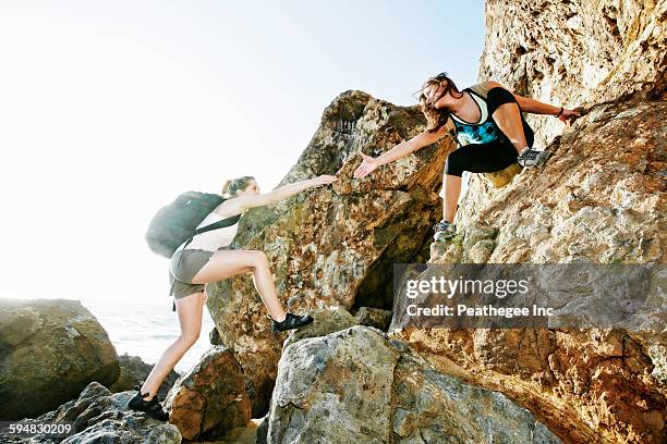 women climbing on boulders - women rock climbing stock pictures, royalty-free photos & images