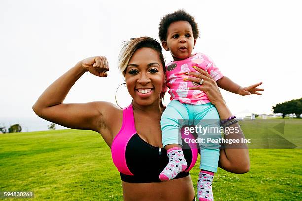 Black woman holding daughter in field