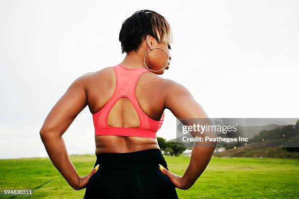 black woman standing in field - hoop earring 個照片及圖片檔