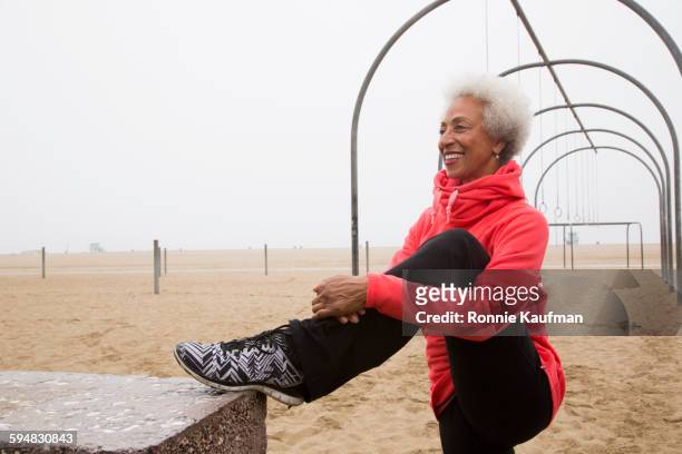 African American woman stretching on beach