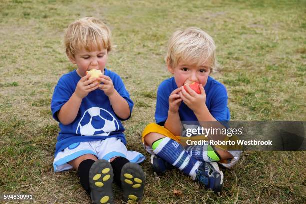 caucasian soccer players eating apples - fußballtrikot stock-fotos und bilder