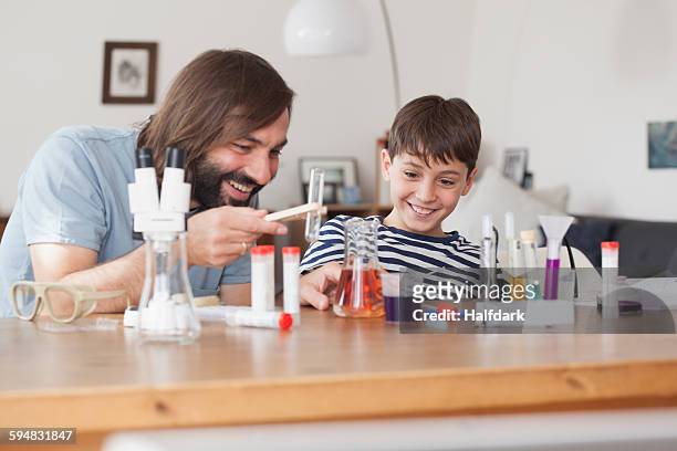 father and son working on school science project at home - chemistry set stock pictures, royalty-free photos & images
