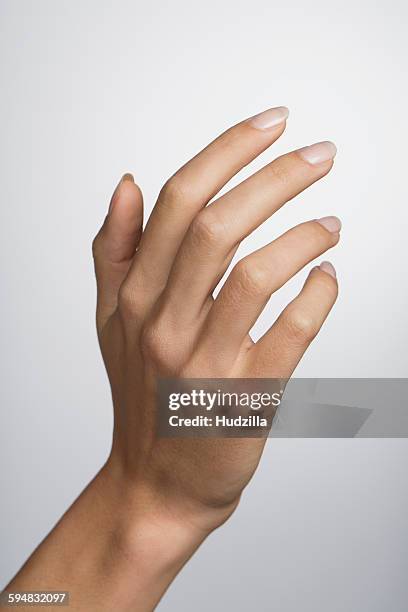 cropped hand of woman against white background - fingernail foto e immagini stock
