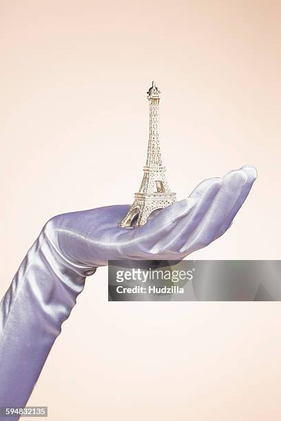 cropped hand of bride holding eiffel tower model against colored background - formal glove bildbanksfoton och bilder