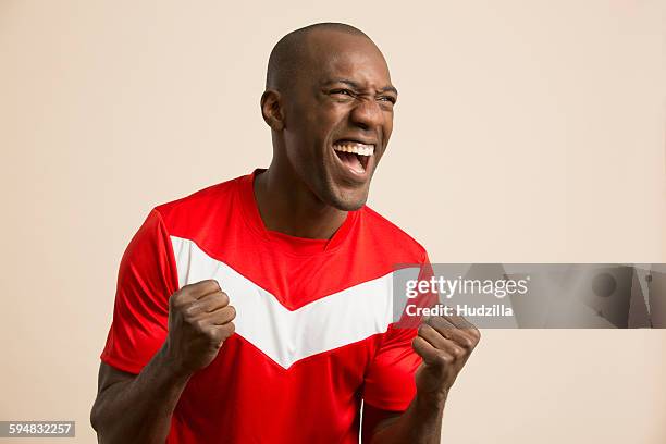 excited soccer player cheering against colored background - careca - fotografias e filmes do acervo