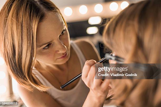 artist applying make-up on fashion model - makeup artist stock pictures, royalty-free photos & images