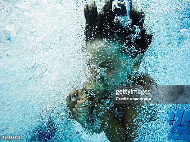 boy holding his nose, jumping into a swimming pool - 鼻をつまむ ストックフォトと画像